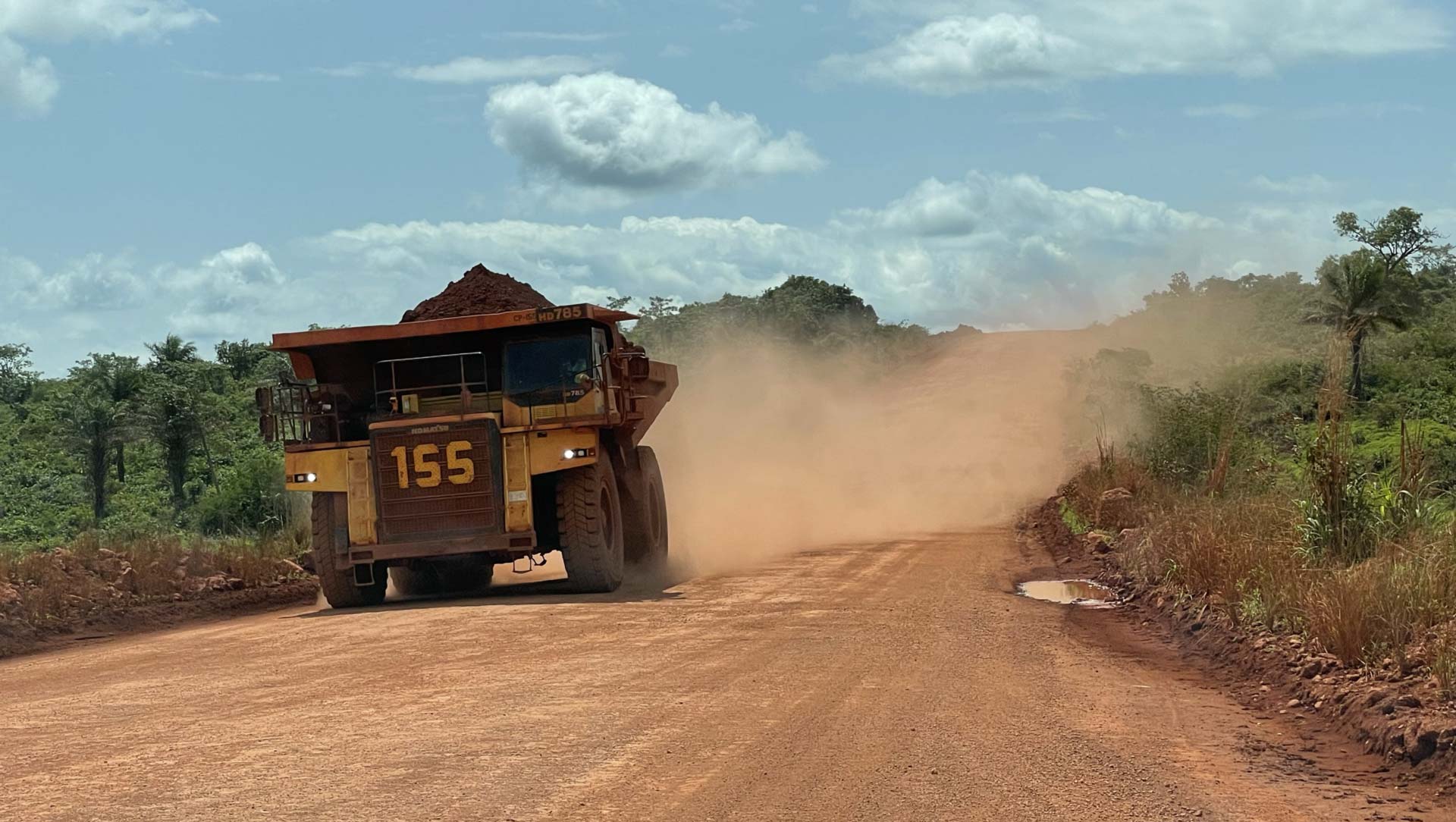 Trucks carrying bauxite away from the mining site.